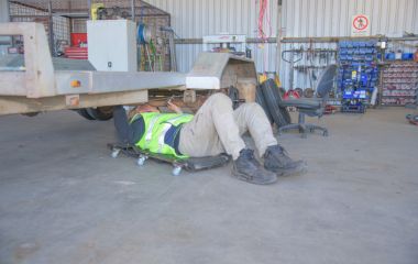 Our Mechanic inspecting the undercarriage of a trailer at Busselton Equipment Hire