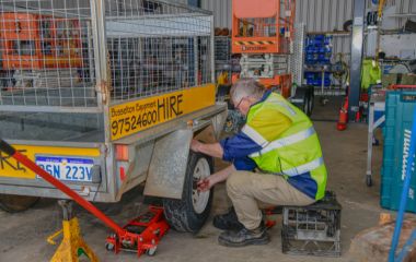 Mechanic carefully repairing a trailer wheel at Busselton Equipment Hire – quality workmanship for trailer repairs Busselton.
