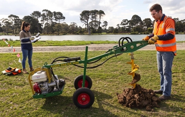 Two people operating a hydraulic post hole digger in South West WA soil. AI Generated Image